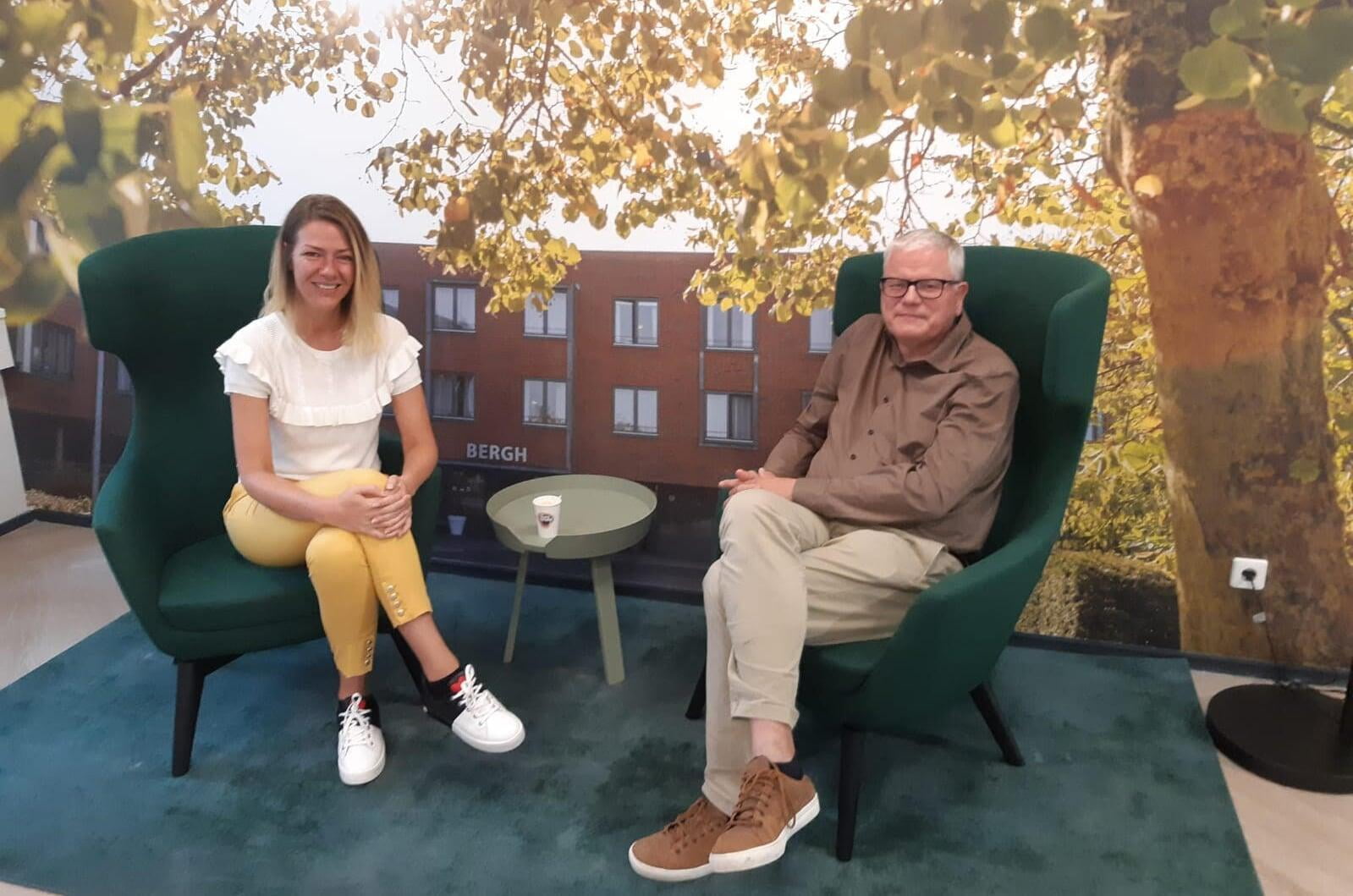 Thijs en Linda zittend in groene fauteuils tijdens het gesprek over het veranderproces